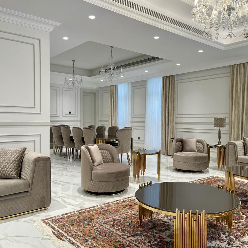 A central coffee table adorned with brass accents serves as a focal point in the majlis.