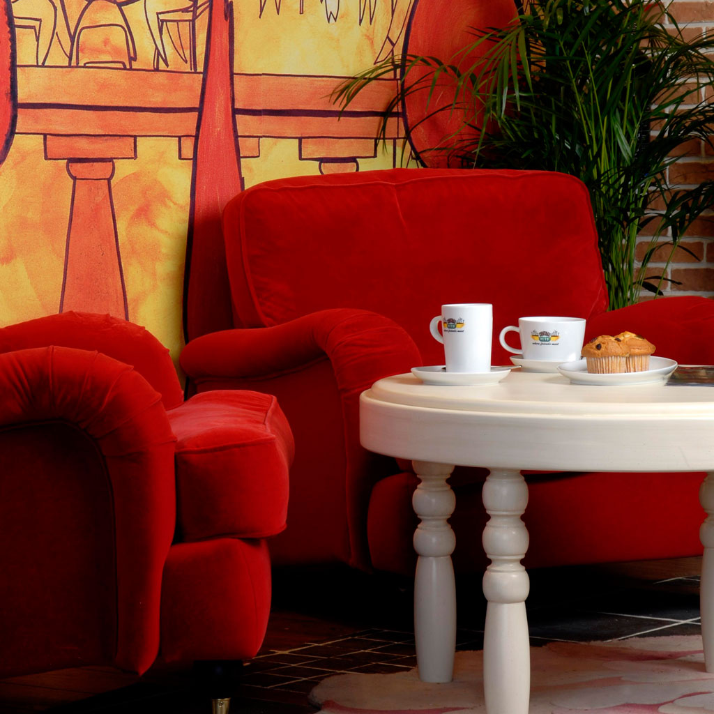 A coffee shop with red armchairs