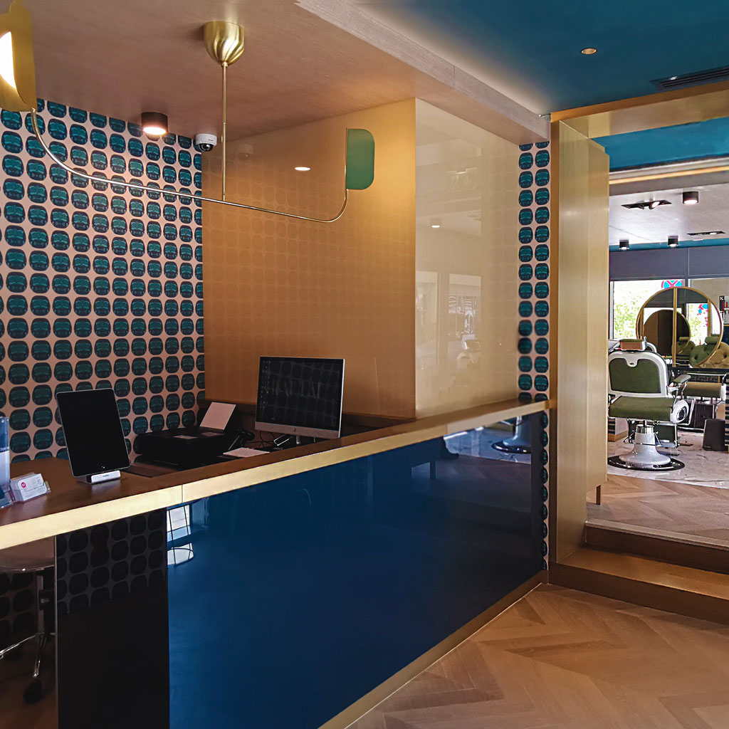 A hair cut parlour reception area with a feature wall and a designer counter
